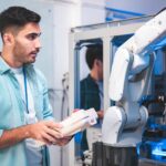 Étudiant travaillant sur un bras robotique nécessaire dans l'industrie